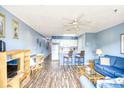 Open-concept living room with wood floors, bar seating and comfortable furnishings at 1210 N Ocean Blvd. # 202, Surfside Beach, SC 29575