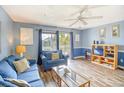 Living room features a blue couch, wood floors, and a view of the balcony at 1210 N Ocean Blvd. # 202, Surfside Beach, SC 29575