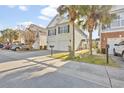 A charming two-story home with a two-car garage, complemented by palm trees and a manicured lawn at 1335 Wading Bird Ln., Myrtle Beach, SC 29577