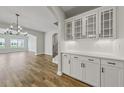 Dining area featuring stylish white cabinetry, a serving counter, and an arched doorway to the living space at 177 Azure Loop, Myrtle Beach, SC 29588