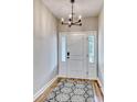 Bright foyer featuring a modern chandelier, a white front door with sidelights, and stylish wood-look flooring at 177 Azure Loop, Myrtle Beach, SC 29588