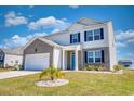 Charming two-story home featuring blue shutters, a well-manicured lawn, and beautiful landscaping at 2106 Ainsley Dr., Little River, SC 29566