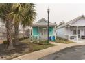 Beach cottage with a quaint front porch and turquoise siding on a misty day at 230 Addison Cottage Way, Murrells Inlet, SC 29576