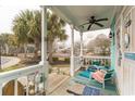 Inviting front porch with seating, ceiling fan, and coastal decor and a view of the lawn at 230 Addison Cottage Way, Murrells Inlet, SC 29576