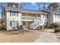 Exterior of a two-story condo featuring a white staircase and well-maintained landscaping at 3555 Highway 544 # 17F, Conway, SC 29526