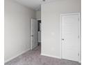 Bedroom with neutral walls and carpet, featuring a closet and two entry doors at 455 Falling Leaf Loop, Myrtle Beach, SC 29588