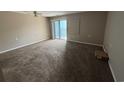 Open living space with neutral walls, plush carpeting, and a sliding glass door to a balcony at 5001 Little River Rd. # E-312, Myrtle Beach, SC 29577