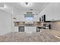 A modern kitchen boasts stainless steel appliances, stone countertops, and ample white cabinetry at 5750 Oyster Catcher Dr. # 533, North Myrtle Beach, SC 29582