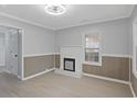 Bright living room with a decorative fireplace, wainscoting, and new flooring at 708 Bobby L. Davis Blvd., Marion, SC 29571