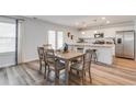 Sunlit dining area with a six-chair table located next to the open kitchen and stainless steel appliances at 911 Agostino Dr., Myrtle Beach, SC 29579