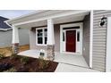 The inviting front porch has stone accents, white columns and a red front door at 1091 Forest Bend Dr., Calabash, NC 28467