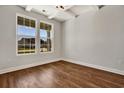 Bright bedroom featuring hardwood floors, white trim, and large windows offering plenty of natural light at 1111 Forest Bend Dr., Calabash, NC 28467