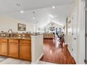 Open-concept kitchen with granite countertops and rich wood floors leading to the living room at 1166 Bethpage Dr., Myrtle Beach, SC 29579