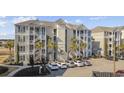 Exterior view of condo building showcasing stairs, parking, and proximity to a waterway at 117 Ella Kinley Circle # 302, Myrtle Beach, SC 29588