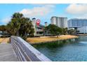 Beautiful condo features a deck overlooking a serene pond with tropical landscaping and a modern high-rise in the distance at 129 Hartland Dr. # 8-I, Myrtle Beach, SC 29572