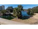 A picturesque bridge crosses a calm pond with lush greenery and high-rise buildings in the background at 129 Hartland Dr. # 8-I, Myrtle Beach, SC 29572