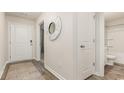 Inviting hallway with wood-look flooring, a decorative mirror, and access to the bathroom at 153 Leyland Cypress Dr, Conway, SC 29527