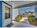 Inviting condo entrance leading to a tranquil pond view and landscaped grounds at 2151 Clearwater Dr. # C, Surfside Beach, SC 29575