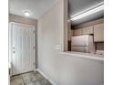 Hallway with tile flooring that leads to a galley-style kitchen featuring white appliances at 2151 Clearwater Dr. # C, Surfside Beach, SC 29575
