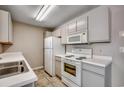 Galley-style kitchen with white appliances, tile floors and ample counter space at 2151 Clearwater Dr. # C, Surfside Beach, SC 29575
