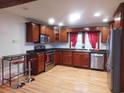 Well-lit kitchen featuring stainless steel appliances, dark countertops, and warm wooden cabinetry at 223 Greentown Rd., Georgetown, SC 29440