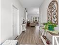 Bright hallway with wood floors, decorative tables, and a view into the living area at 250 Ole Maple St., Loris, SC 29569