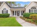 Inviting front entrance featuring a covered porch with decorative columns and manicured shrubbery at 3471 Spivey St., Loris, SC 29569