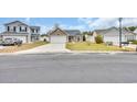 A well-maintained tan one-story home featuring an attached two-car garage and a green front lawn at 378 Thistle Ln., Myrtle Beach, SC 29579