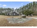 Exterior view of home showing the backyard with a stone patio and a well at 4612 Red Bluff Rd., Loris, SC 29569