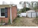 View of a backyard with a fence, storage sheds, and some sparse vegetation at 4649 Tarpon Bay Rd., Myrtle Beach, SC 29579