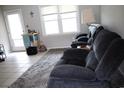 Cozy living room with a plush grey recliner, a soft rug, and natural light from the windows at 4649 Tarpon Bay Rd., Myrtle Beach, SC 29579