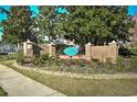 Beautifully landscaped community entrance with brick pillars and mature trees at The Fountains at 5046 Belleglen Court # 101, Myrtle Beach, SC 29579