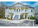 Attractive yellow condo building featuring white stairs and well-maintained landscaping in a community setting at 5046 Belleglen Court # 101, Myrtle Beach, SC 29579