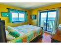 Inviting bedroom with bright yellow walls, offers ocean views, and sliding glass door leading to a private balcony at 5905 S Kings Hwy. # 1801-C, Myrtle Beach, SC 29575