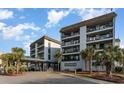 Condo exterior showcasing a covered entrance, palms, and a tidy landscape, enhancing its welcoming and charming aesthetic appeal at 5905 S Kings Hwy. # 235B, Myrtle Beach, SC 29575