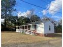 Side view of brick home showing long, covered porch with ramp at 611 E Ashland St., Andrews, SC 29510