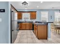 Functional kitchen featuring wooden cabinets, stainless steel appliances, and tile flooring with view into dining area at 624-B Seabreeze Dr., Garden City Beach, SC 29576