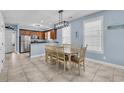 Bright eat-in kitchen featuring tile floors, light blue walls, and a dining table with seating for six at 624-B Seabreeze Dr., Garden City Beach, SC 29576