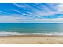 A beach view of clear blue ocean, white sand, blue skies, and soft waves at 6900 N Ocean Blvd. # 1536, Myrtle Beach, SC 29572