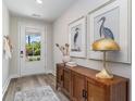 Inviting entryway with wood-look floors, stylish cabinet, and natural light at 815 Ireland Dr., Longs, SC 29568