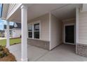 Close up of an entryway and front porch, highlighting the architectural details at 8713 High Banks Way, Longs, SC 29568