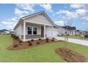 Inviting home exterior with a well-kept lawn, landscaping and a two car garage at 8713 High Banks Way, Longs, SC 29568