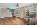 Bright living room with wood floors, paneled walls, two windows, and a comfortable recliner at 1032 N Ocean Blvd., Surfside Beach, SC 29575