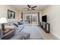 Comfortable living room with a ceiling fan, sliding glass doors, and neutral decor at 1250 River Oaks Dr. # 16B, Myrtle Beach, SC 29579