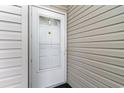 Exterior view shows the front door with glass window and white trim and light siding at 130 Lazy Willow Ln. # 204, Myrtle Beach, SC 29588