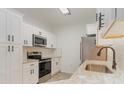 Bright kitchen features stainless steel appliances, white cabinetry and sink with modern faucet at 130 Lazy Willow Ln. # 204, Myrtle Beach, SC 29588