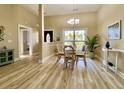 Inviting dining room showcasing wood floors, a chandelier, a table with four chairs, and a large window at 144 Harbor Lights Dr., Surfside Beach, SC 29575