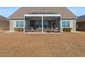 View of the home's exterior featuring an enclosed patio with stylish furniture perfect for outdoor entertaining at 1685 Sapphire Dr., Longs, SC 29568