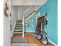 Bright foyer with wood floors, a staircase, and aqua accent wall, creating a welcoming entrance at 1849 Crooked Pine Dr. # C-5, Surfside Beach, SC 29575