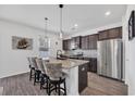 Kitchen showcasing a granite island with seating, dark cabinets, and stainless steel appliances at 220 Forestbrook Cove Circle, Myrtle Beach, SC 29588